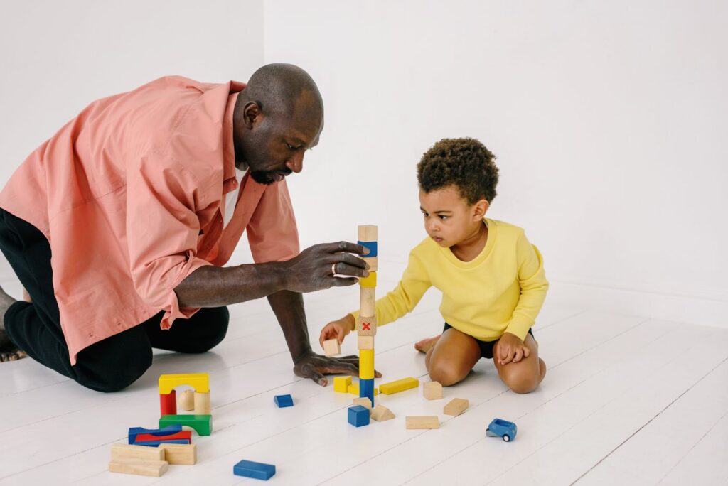 Un père et son enfant construisent une tour de cubes